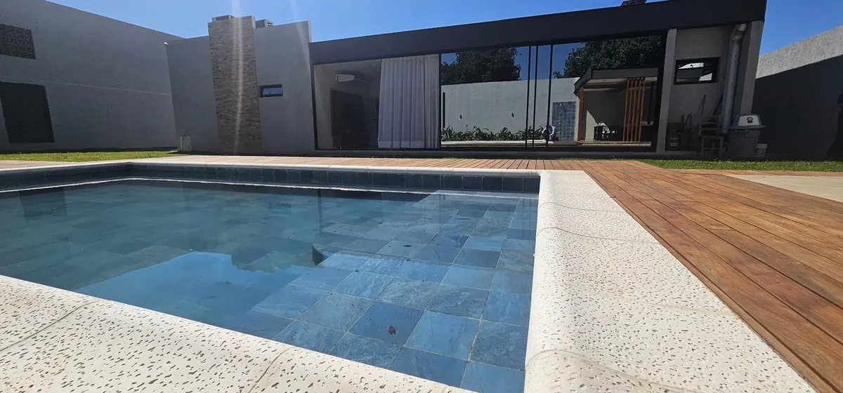 Piscina con deck de madera y fachada de la Residencial Ortiz