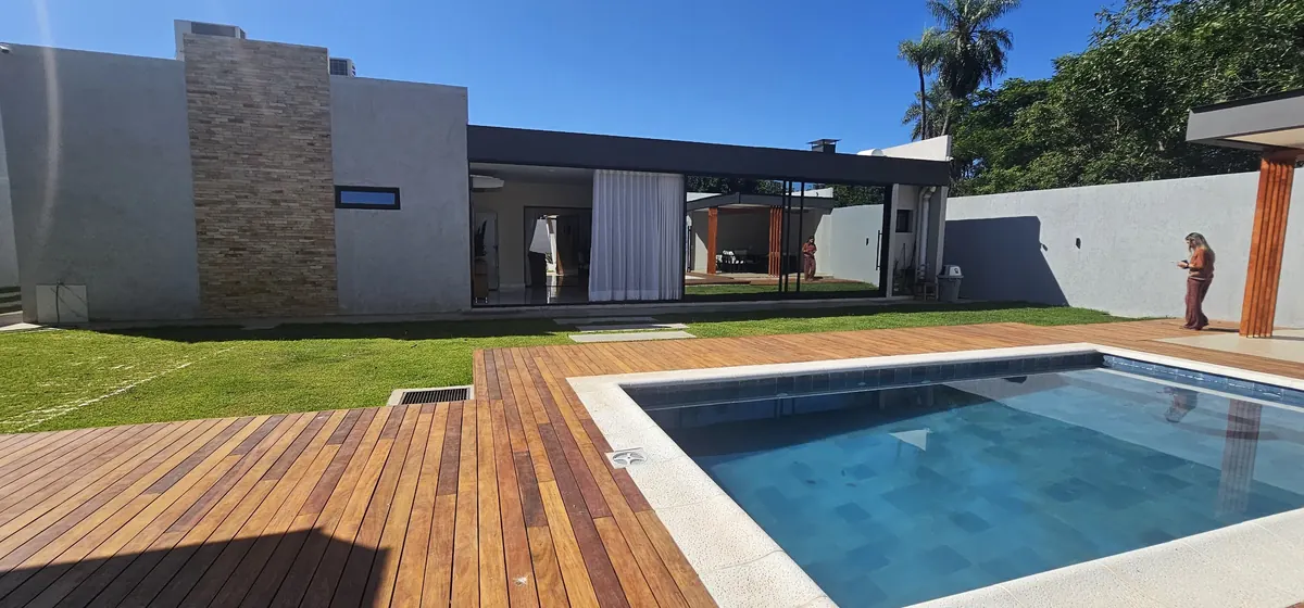 Piscina y deck de madera con la casa al fondo