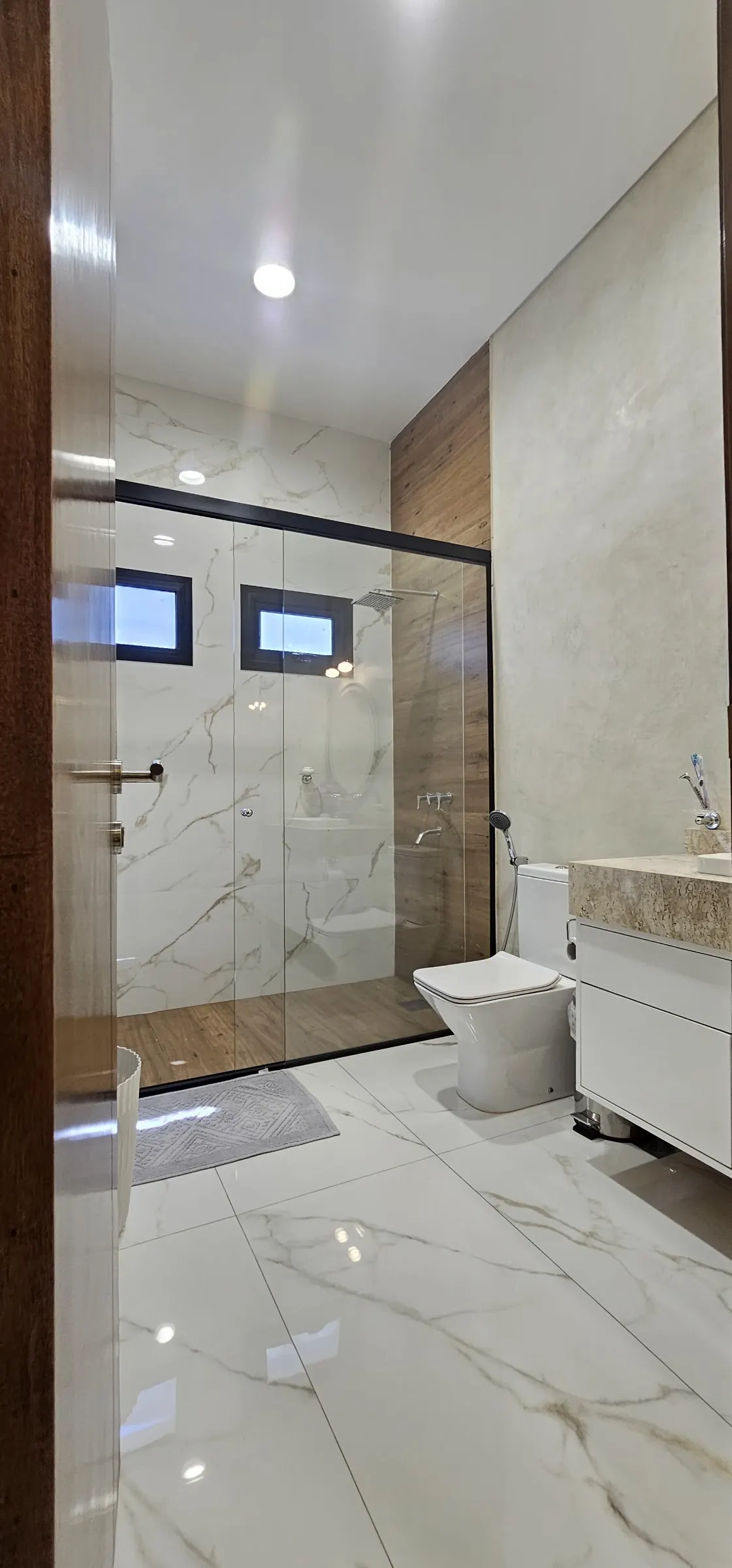 Baño con revestimiento de porcelanato tipo mármol